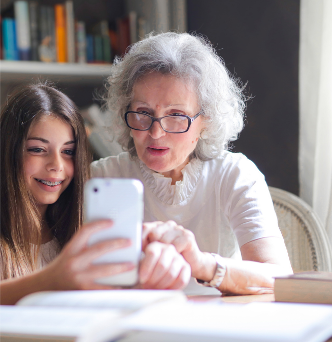 Grandmother and daughter looking at cellular phone